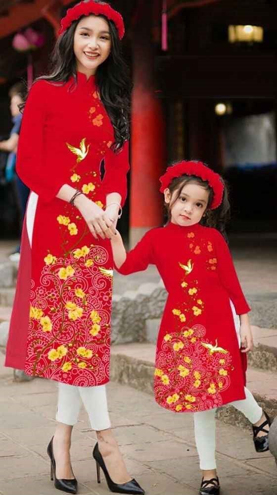 赤いアオザイを着た子供と女性